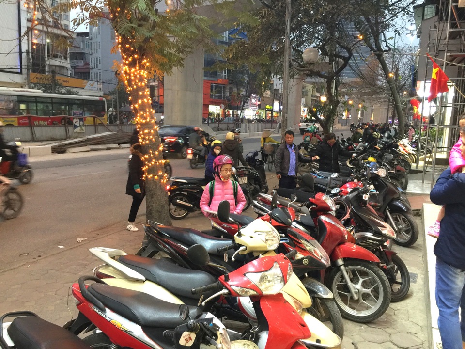 Hàng quần áo khuyến mãi "khủng", dân công sở sắm Tết xuyên trưa - 7 Nhiều cửa hàng quần áo trên phố Cầu Giấy kín đặc chỗ để xe, nhiều nơi người dân để tràn ra đường, tranh thủ mua sắm.