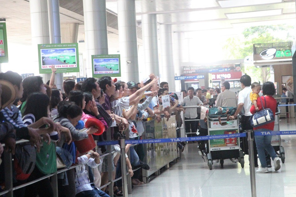 Vui mừng vẫy chào người thân đã đáp chuyến bay an toàn xuống Tân Sơn Nhất