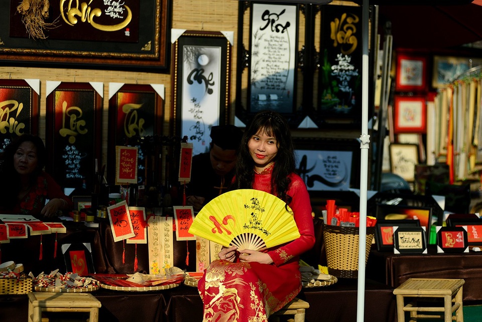 Thiếu nữ bên quầy viết thư pháp của ông đồ.