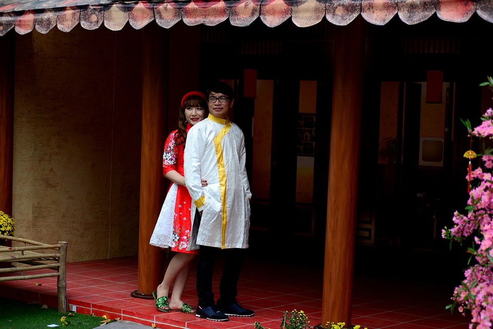 Hai bạn trẻ chụp hình dưới ngôi nhà được thiết kế kiểu xưa.