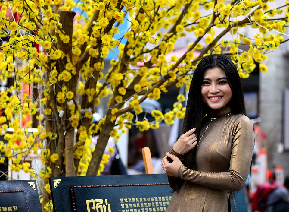 Những thiếu nữ xinh đẹp trong tà áo dài bước xuống phố ông đồ chụp hình đón xuân.