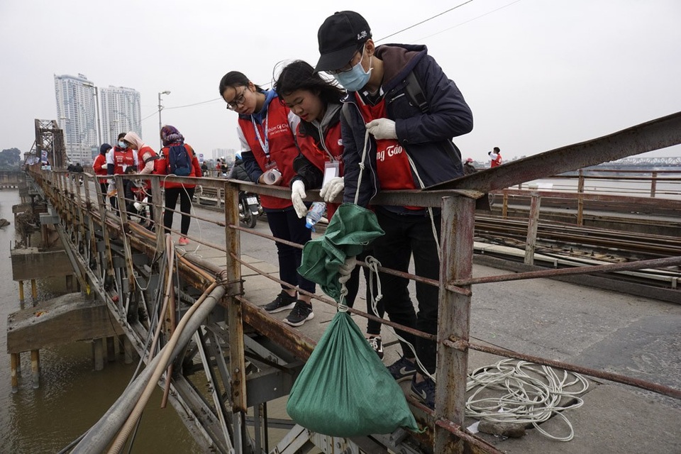 
Công việc của họ trong những ngày này là có mặt ở cầu Long Biên từ 7h sáng đến chiều muộn, họ tiếp nhận cá, tro của người dân rồi thả xuống Sông Hồng bằng thùng nhựa có buộc dây thừng hạ sâu xuống tận mặt nước đảm bảo an toàn cho cá khi tiếp nước.
