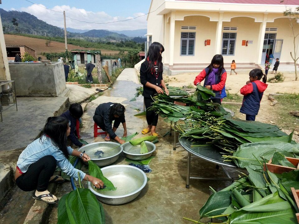 “Thầy cô cắm bản” gói bánh chưng, mổ heo cho học sinh ăn Tết - 1 Những bạn học sinh nữ thì phụ rửa lá gói bánh