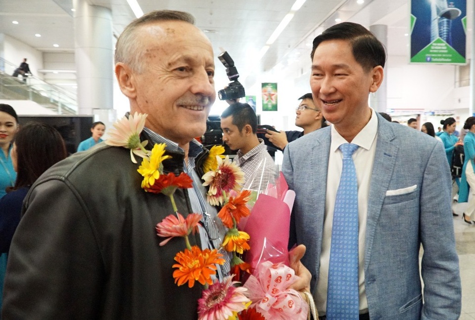 Ông Trần Vĩnh Tuyến (bên phải) tặng hoa cho những vị khách “xông đất” TPHCM sáng 1/1. Trong ảnh là ông Parent Francois, quốc tịch Pháp vui cười khi được lãnh đạo Thành phố ra tiếp đón