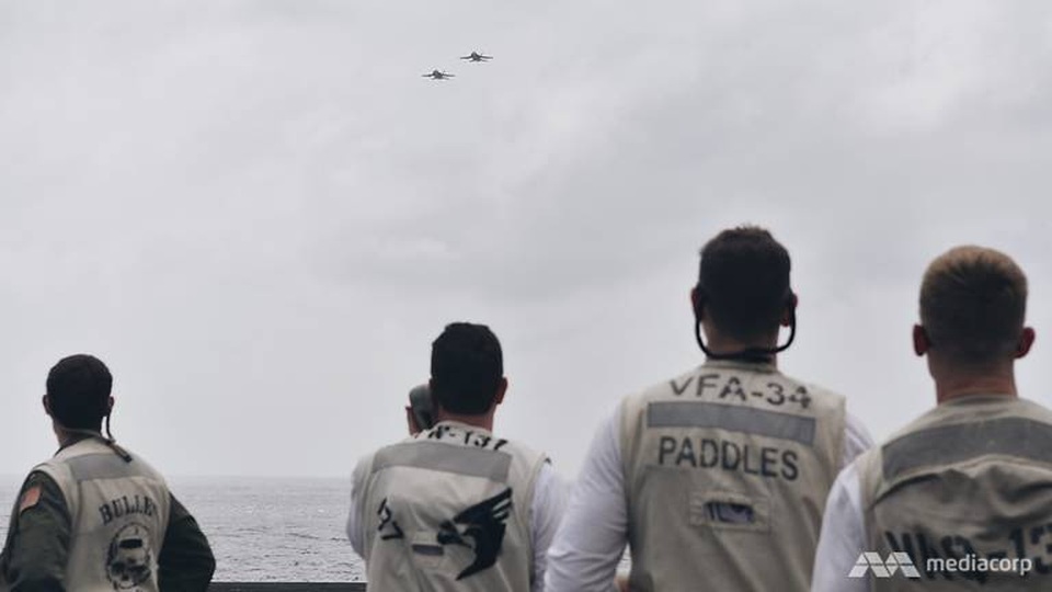 Cuộc sống trên “thành phố nổi” USS Carl Vinson vừa thăm Việt Nam - 3 “Chúng sẽ giúp các bạn an toàn, phòng khi các bạn bị rơi xuống nước. Sẽ không xảy ra đâu, nhưng cũng có khả năng”, ông Berry nói với các phóng viên về áo phao. Trong ảnh: Các sĩ quan phụ trách máy bay hạ cánh và các quan sát viên an toàn nhìn theo những máy bay chuẩn bị hạ cánh. (Ảnh: Mediacorp)