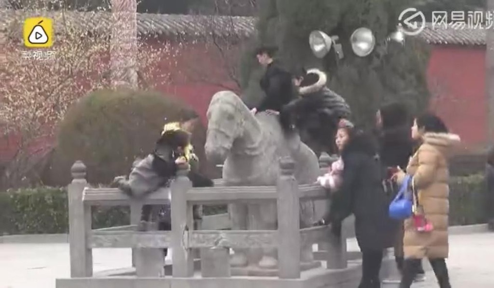 Bất chấp cảnh báo, nhóm khách Trung Quốc vẫn trèo lên tượng ngựa đá 1000 năm tuổi trong một ngôi đền ở thành phố Lạc Dương