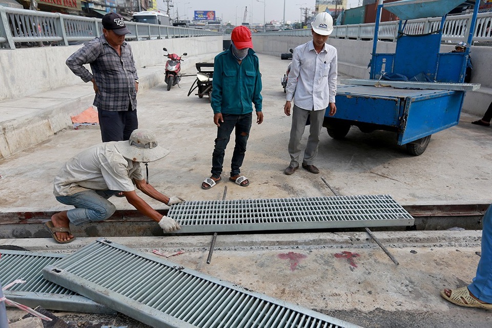Toàn cảnh hầm chui sắp thông xe tại cửa ngõ Tây Bắc TPHCM - 8 Công nhân đậy những tấm đan bằng thép lên rãnh thoát nước trong hầm kín và hầm hở.