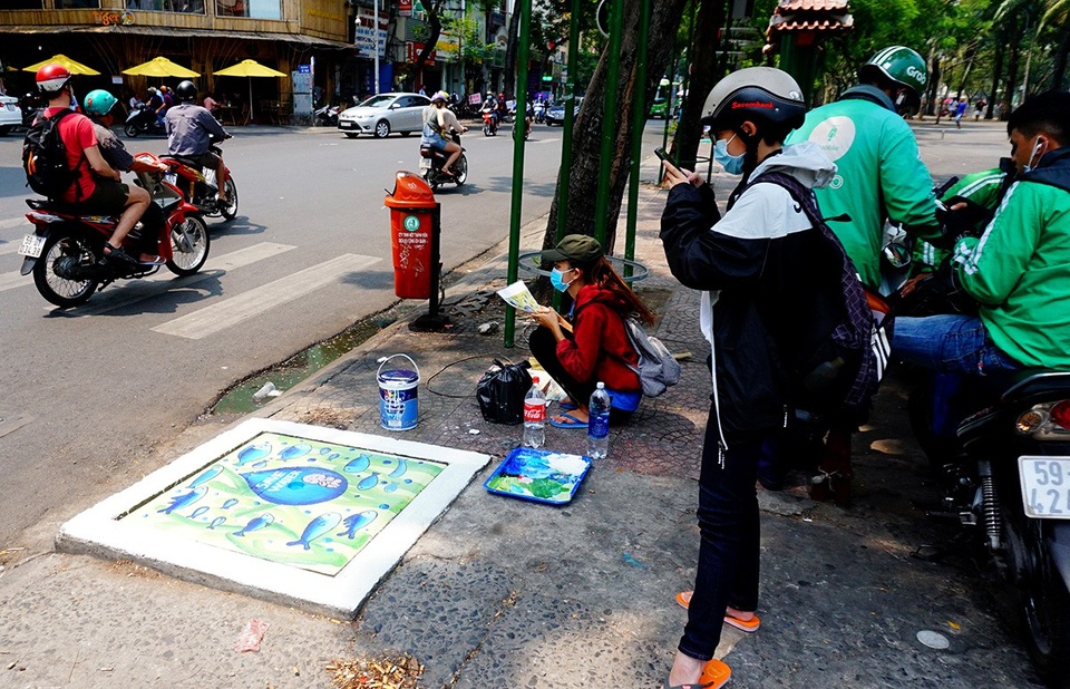 100 nắp cống ở trung tâm TPHCM "khoác áo mới" - 7 Có người dùng điện thoại quay phim lại.
