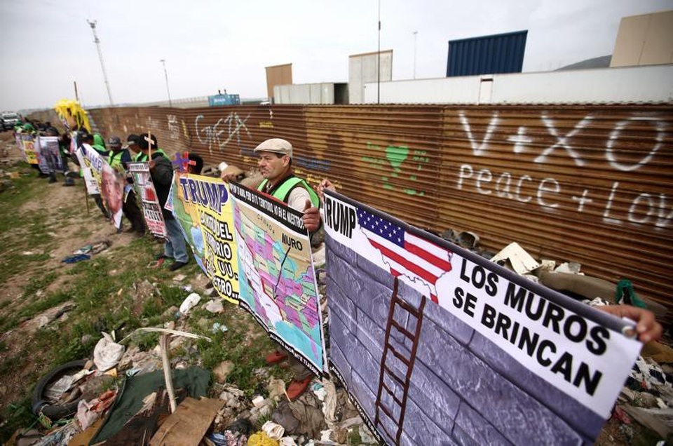 Ông Trump thị sát tường biên giới gây tranh cãi với Mexico - 9 Ước tính tường biên giới Mỹ - Mexico sẽ dài khoảng 3.200 km và tốn khoảng 20 tỷ USD kinh phí xây dựng. Trong ảnh: Người biểu tình xếp hàng dọc hàng rào ngăn biên giới Mỹ - Mexico hiện thời ở Tijuana.
