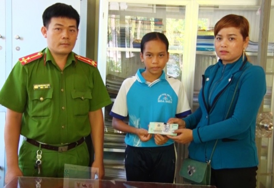 
Đại diện công an xã Thuận Yên cùng em Huỳnh Thị Bích Trâm trao lại số tiền 37 triệu đồng cho chị Châu Thị Sành. (Ảnh: Anh Tuấn)
