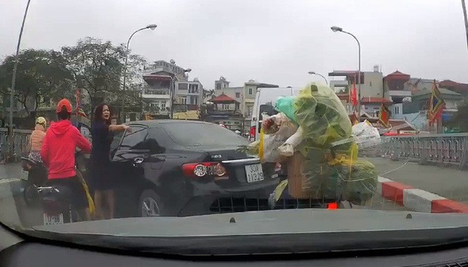Khó xử phạt nữ tài xế lùi quay xe trên cầu, gây gổ với người đi xe máy? - 1
Nữ tài xế đi ô tô chỉ tay, đôi co với người đi xe máy ngay trên khu vực cầu đang đông đúc dòng phương tiện qua lại. (Ảnh cắt từ clip)