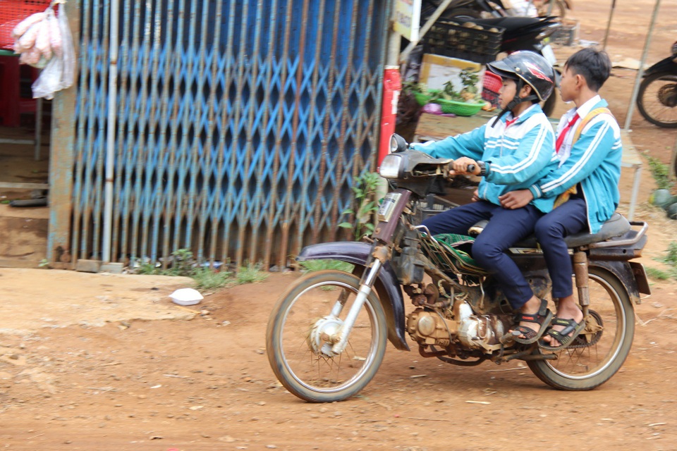 Đắk Nông: Học sinh đeo khăn quàng đỏ vô tư điều khiển xe máy tới trường - 3 Một số em chở thêm người phía sau, không đội mũ