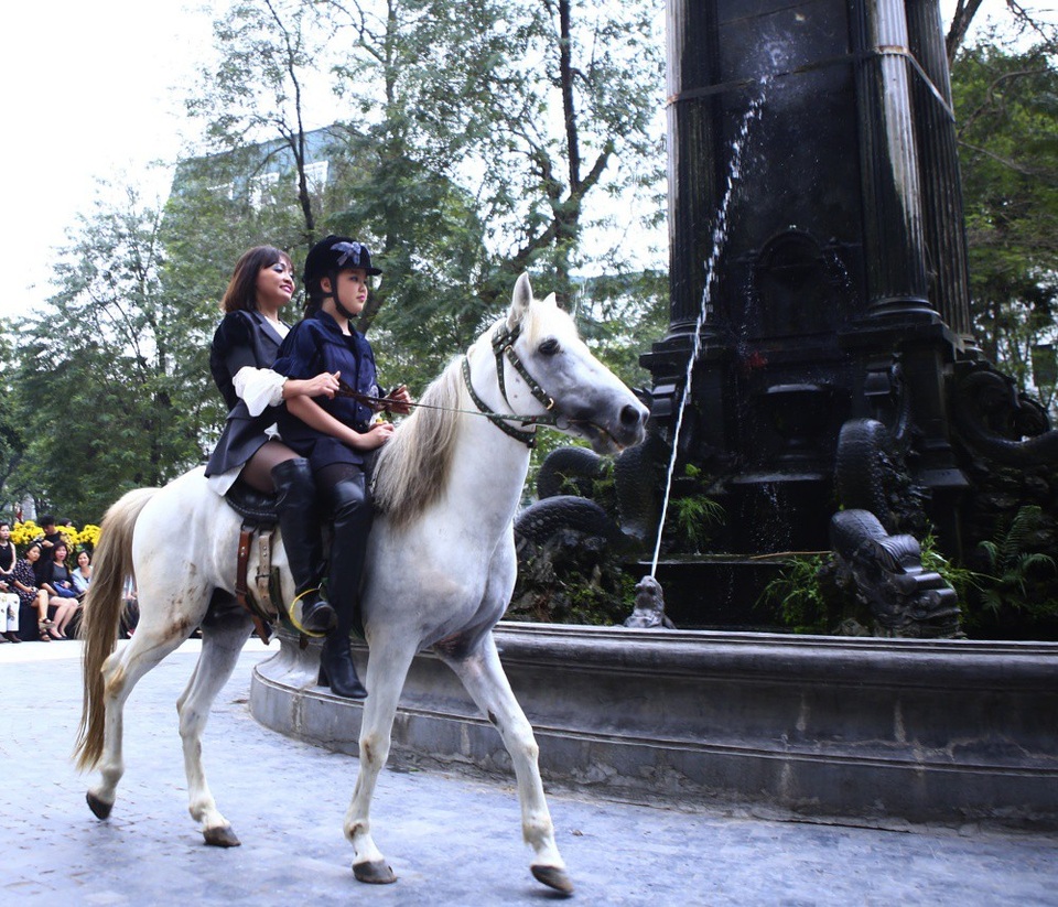 NTK Minh Hạnh đưa ngựa trắng lên sàn diễn Tuần lễ thời trang Việt Nam - Italia - 4 Sự xuất hiện của chú ngựa trắng và diễn viên từ Liên đoàn xiếc, tiếp đó là một người mẫu nhỏ tuổi đã khuấy động không gian vườn hoa con cóc.