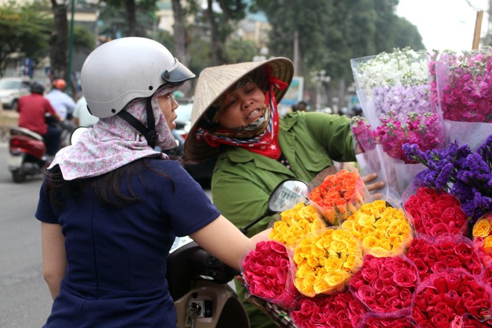 Đại gia đình bỏ quê lên phố, mỗi ngày đạp xe 50 km kiếm sống - 7
Chị Dịu đang bán hoa cho khách