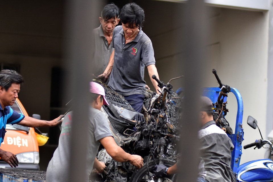 Phía mặt bên kia của chung cư, đội dọn dẹp vẫn hì hục với những khung xe