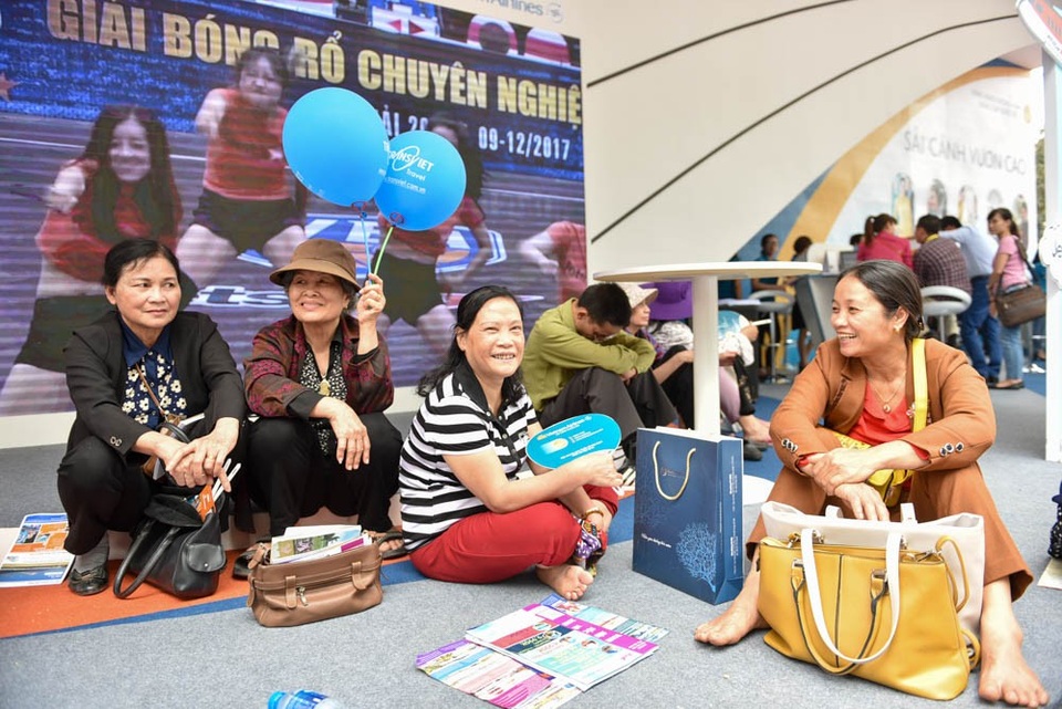 Một đoàn khách trực chiến xuyên trưa lấy số thứ tự mua vé máy bay giá rẻ tại gian hàng của Jetstar Pacific