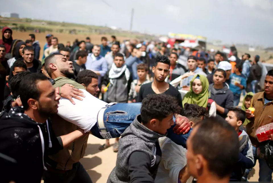 Đụng độ đẫm máu ở Dải Gaza, hơn 1.000 người thương vong - 4
Một người biểu tình Palestine bị thương. Ảnh: Reuters