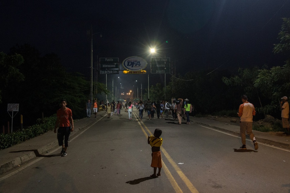 Cuộc di dân khổng lồ trốn chạy nạn đói của người Venezuela - 1 Một cậu bé Venezuela đứng giữa cây cầu biên giới với Colombia. (Ảnh: NYT)