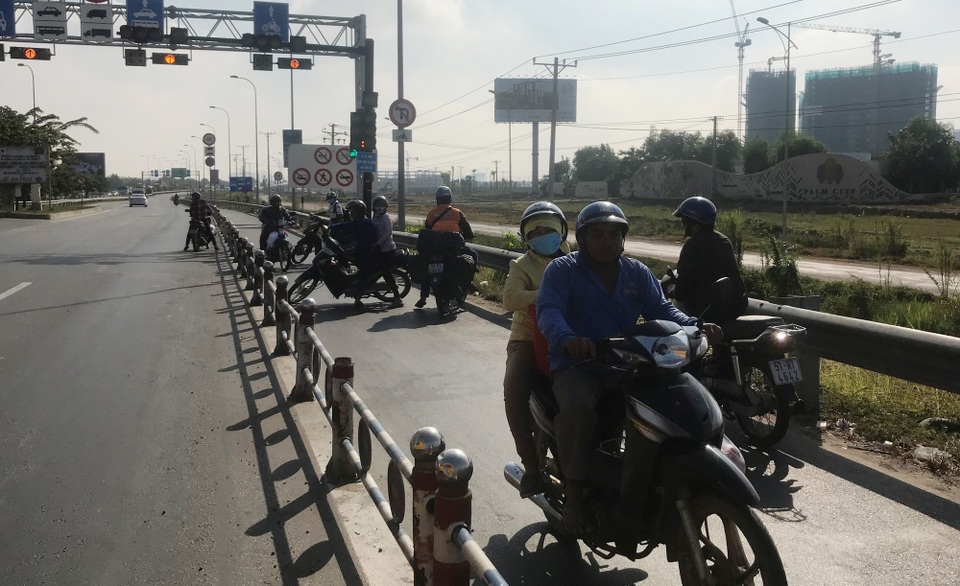 
Nhiều người bất chấp nguy hiểm, quay đầu xe rồi chạy ngược chiều trở lại đường Nguyễn Thị Định gây cảnh hỗn loạn giao thông.
