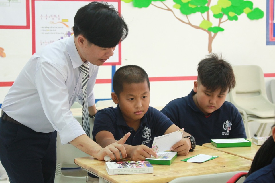 Trao hơn 30.000 bộ flashcard lan tỏa tinh thần nhân bản sống đẹp cho HS, SV - 3 Thầy giáo Hiến Chương, Trường quốc tế song ngữ Học viện Anh quốc UK Academy đang giải thích ý nghĩa danh ngôn trên những tấm card cho học sinh.