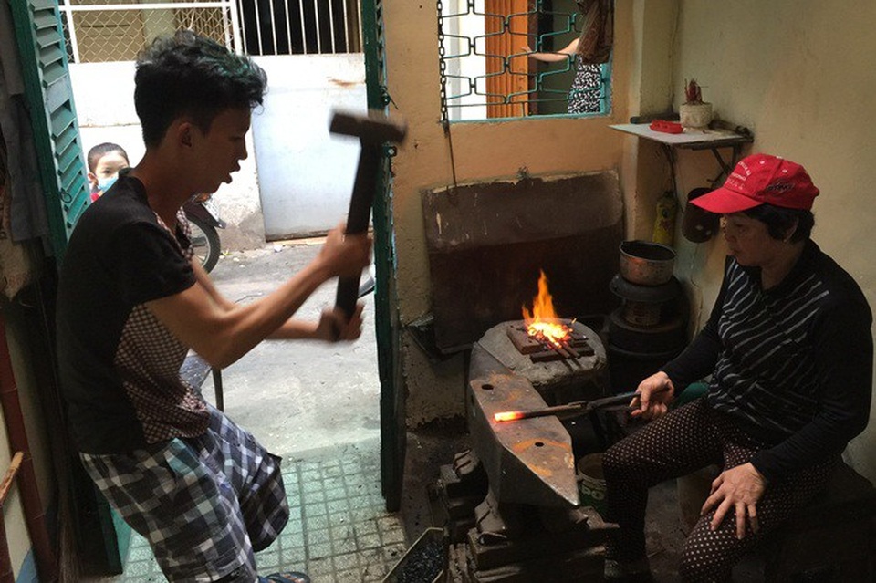 Món quà đặc biệt ngày 8/3 của nữ thợ rèn ở Sài Gòn - 2 Vinh, con trai chị Nguyệt, đang giúp mẹ.