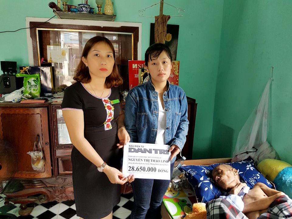 Đại diện lãnh đạo thị trấn Hà Lam (huyện Thăng Bình) trao quà của bạn đọc đến em Linh