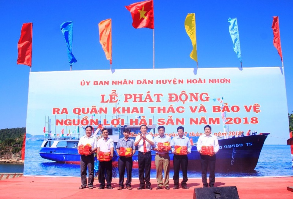 Lãnh đạo huyện Hoài Nhơn tặng cờ Tổ quốc cho đại diện 6 xã ven biển.