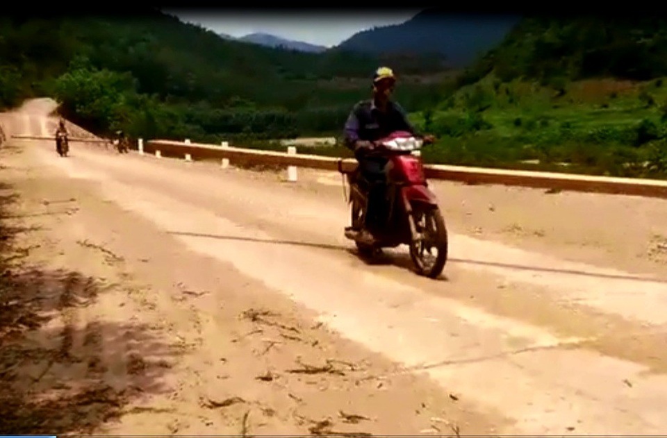 Tận mắt chứng kiến một cánh rừng bị “cưa sạch, đốt sạch” - 6 Hai lâm tặc chở hai khúc gỗ đi trên đường ĐT609. Khúc gỗ được chất nằm ngang, chiếm hết con đường. (Ảnh cắt từ clip)