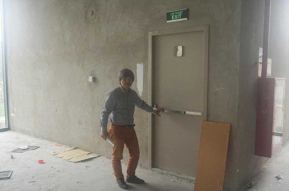 Siêu thị, trường học bịt kín cửa thoát hiểm, khi cháy dân chung cư chạy đi đâu? - 1 Anh Công dẫn phóng viên đi từ tầng 2 xuống lối thoát hiểm qua siêu thị ở tầng 1.