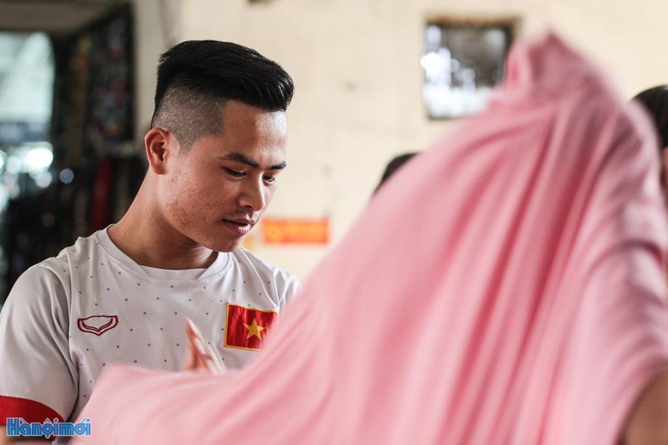 Cực nhọc nghề "cửu vạn" chợ Đồng Xuân - 5 Ngoài việc vận chuyển những chuyến hàng, họ còn phụ giúp các tiểu thương công việc như cuốn vải, sắp xếp hàng...