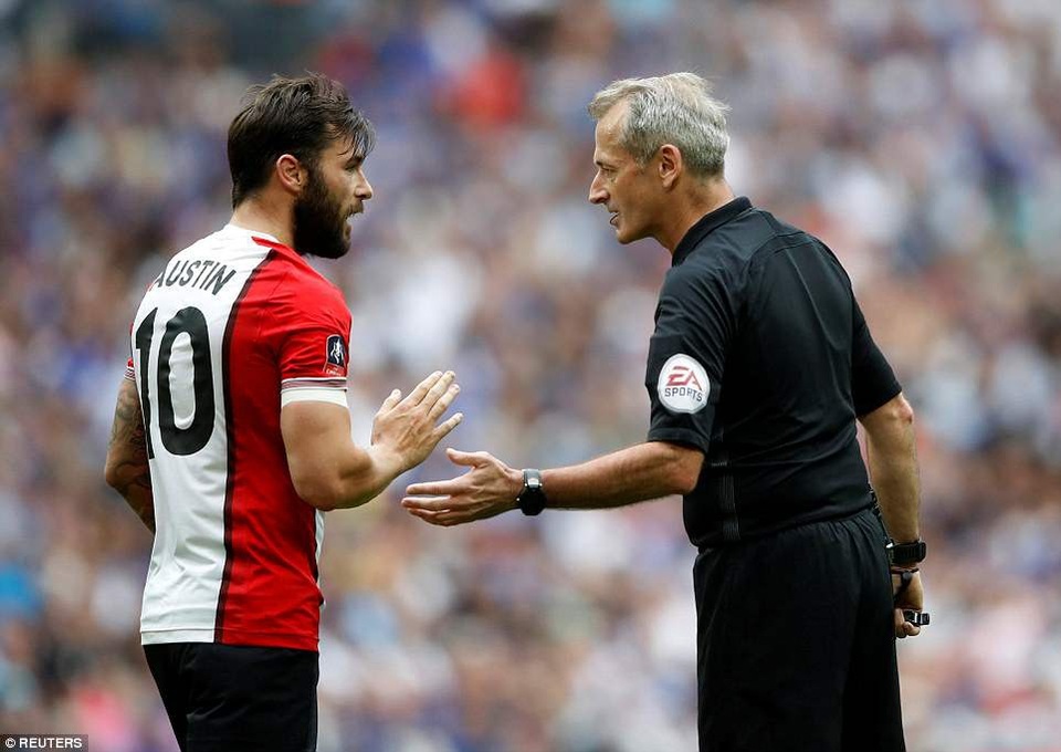 
Tiền đạo Austin (trái) nhận sự nhắc nhở của trọng tài Atkinson
