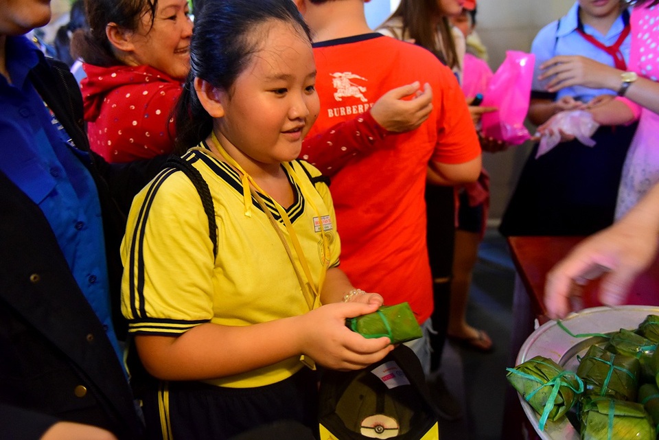 Một em nhỏ dâng lên các vua Hùng bánh chưng, bánh dày.