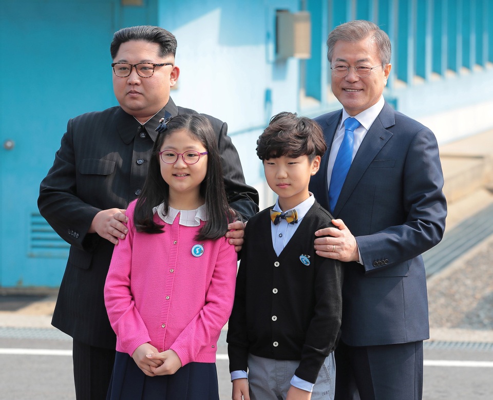 Ông Kim Jong-un bước chân qua ranh giới liên Triều - 7 Ông Kim Jong-un và ông Moon Jae-in cùng nhau chụp ảnh với hai em nhỏ Hàn Quốc tặng hoa cho nhà lãnh đạo Triều Tiên. Đây là hai học sinh tại trường tiểu học ở làng Daeseongdong - ngôi làng duy nhất tại khu phi quân sự liên Triều.