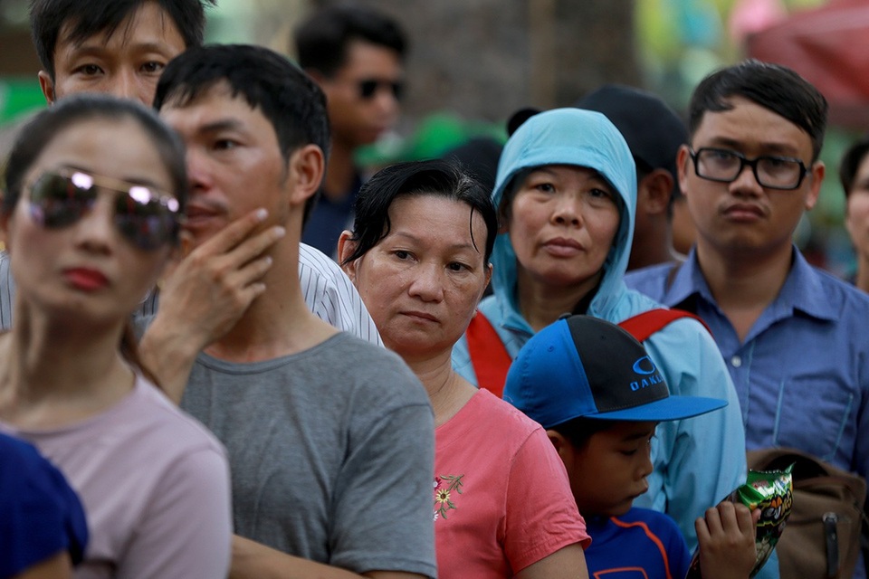 Cảnh du khách đội nắng xếp hàng vào cổng ở các khu vui chơi.