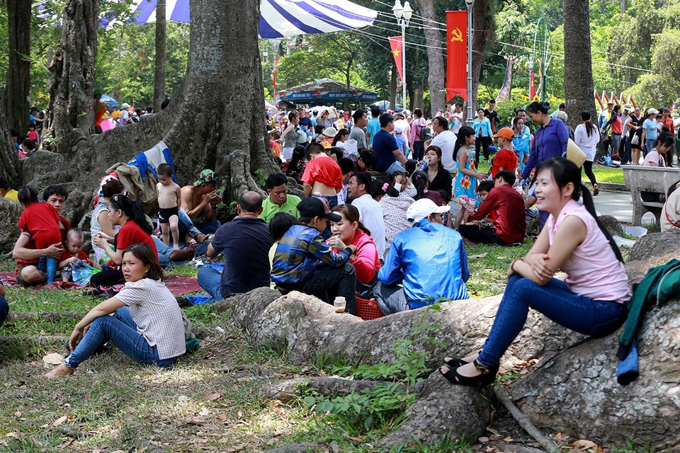 Các gia đình kiếm gốc cây lớn có bóng mát, trải áo mưa ngồi nghỉ ngơi, ăn uống.