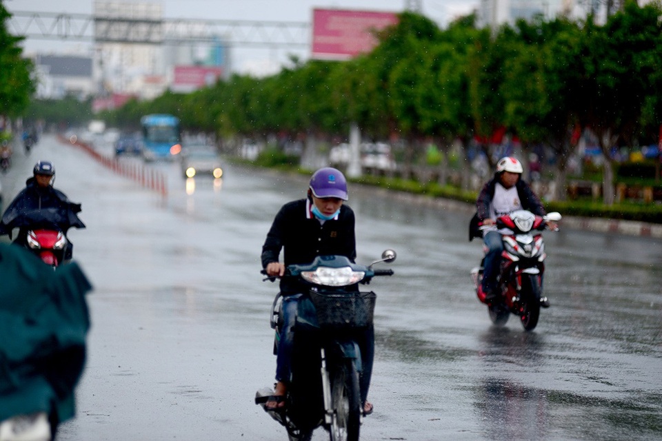 Cơn "mưa vàng" giải nhiệt cho Sài Gòn - 9 Thanh niên đi xe máy khép mình vì không có áo mưa.