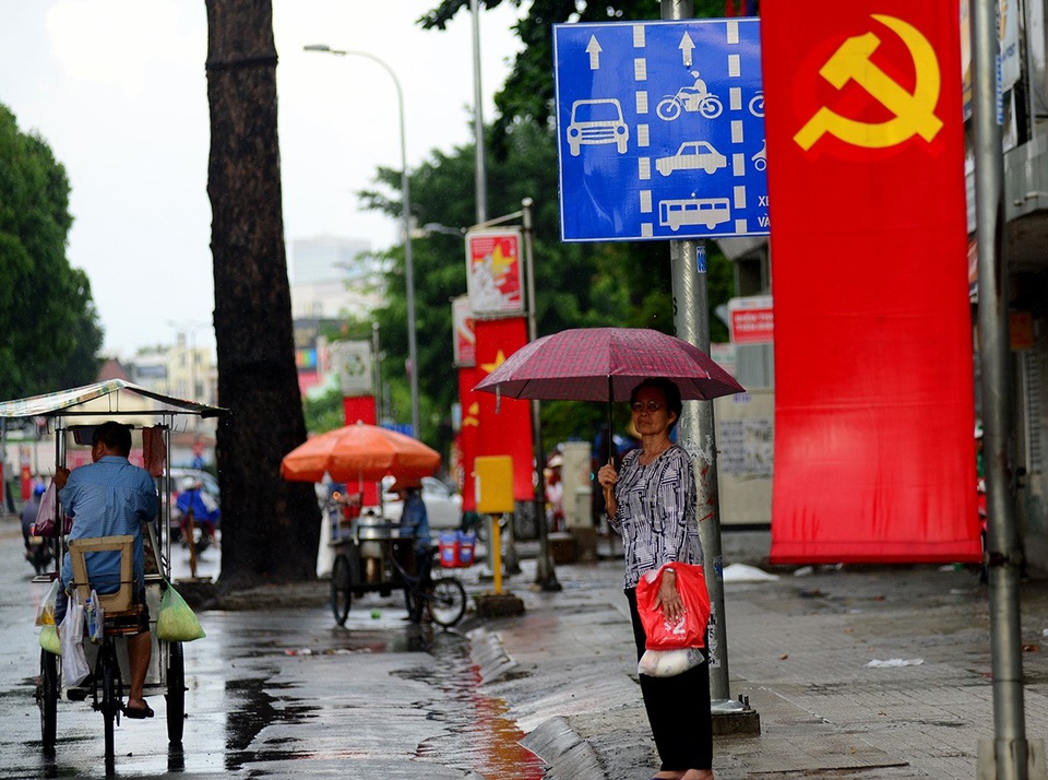 Cơn "mưa vàng" giải nhiệt cho Sài Gòn - 11 Một bà cụ đứng chờ xe bus.