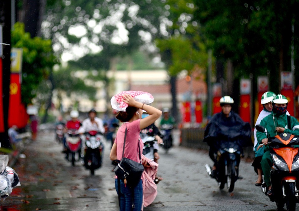 Cơn "mưa vàng" giải nhiệt cho Sài Gòn - 12 Cô gái dùng túi nilon che đầu đi qua đường.