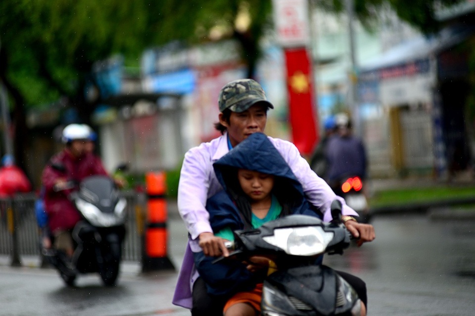 Cơn "mưa vàng" giải nhiệt cho Sài Gòn - 13 Người cha nhường chiếc áo mưa cho cậu con trai.