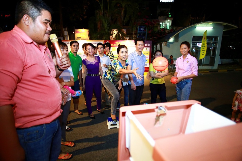 "Mướt mồ hôi" chơi trò ném bóng vào... ngăn tủ - 4 Khách hàng thích thú tham gia trò chơi ném banh, bên dưới chân là “vạch đích” không đụng hàng từ một sản phẩm nhựa của Qui Phúc