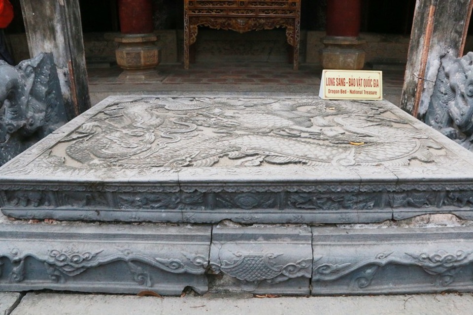 Chiêm ngưỡng cặp long sàng bảo vật độc nhất Việt Nam - 10
Con rồng được khắc trên long sàn trước bái đường cũng đang cuộn tròn mình trên mặt sâp. Các chi của rồng cũng được cách điệu nhân cách hóa rất lạ lẫm và thần bí. Theo đó, 3 chân rồng được cách điệu thành bàn tay con người, mỗi bàn tay thực hiện một nhiệm vụ, không tay nào giống tay nào, tay thì vít chặt sừng rồng, tay nắm chặt bờm...