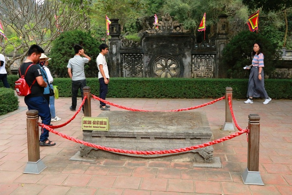 Chiêm ngưỡng cặp long sàng bảo vật độc nhất Việt Nam - 3
Long sàng trước nghi môn ngoại là một tảng đá nguyên khối, chạm khắc thành sập đá hình hộp chữ nhật. Mặt sập có chiều dài 187cm, rộng 127cm; chân đế hơi choãi ra có chiều rộng 134cm, dài 196cm. Trải qua hàng trăm năm đến nay sập đá vẫn tồn tại và vững chãi với thời gian.