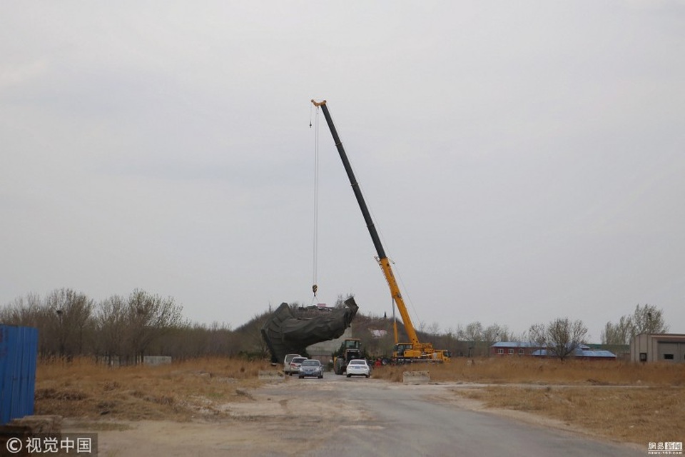 Sau đó, cầu cẩu được huy động tới, đưa bức tượng ra khỏi vị trí cũ để mang đi trùng tu sửa chữa