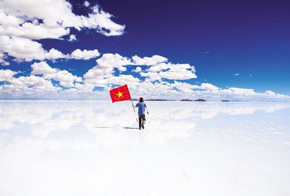 
Anh Nguyễn Hoàng Bảo cầm cờ Tổ quốc tại cánh đồng muối Uyuni de Salar ở Bolivia. Ảnh: NVCC.
