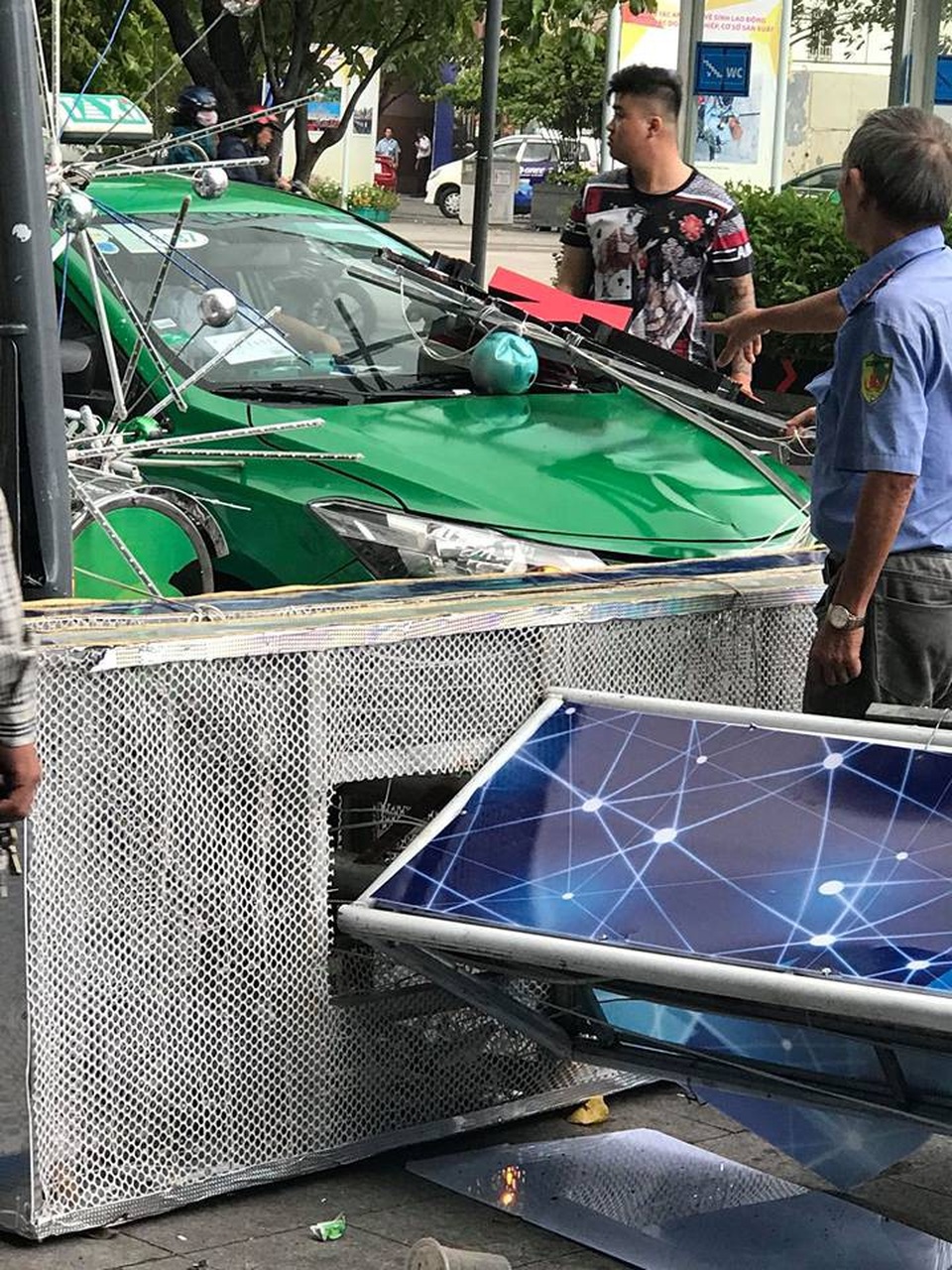 Cổng chào phố đi bộ Nguyễn Huệ đổ sập, đè trúng người đi đường - 3 Một taxi đang lưu thông cũng bị đè trúng phần đầu.