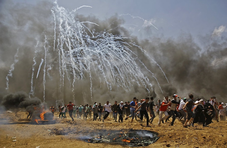 55 người Palestine chết trong đụng độ ở Gaza đúng ngày Mỹ mở sứ quán ở Jerusalem - 9 Ngoài 55 người thiệt mạng, hơn 2.000 cũng bị thương trong vụ đụng độ ở khu vực Gaza giữa Israel và Palestine. Tổng thống Palestine Mahmoud Abbas đã lên án Israel, kêu gọi cộng đồng quốc tế nhanh chóng hành động chống lại “những vụ thảm sát nhằm vào người dân ôn hòa” của Palestine. Trong ảnh: Người Palestine đồng loạt bỏ chạy trong cuộc xung đột với lực lượng an ninh Israel. (Ảnh: AFP)