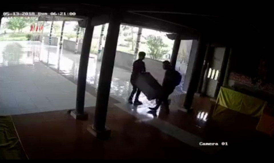 Phát hiện hai đối tượng vào nhà chùa ăn trộm hòm công đức - 1 Hình ảnh hai đối tượng mang hòm công đức ra ngoài.