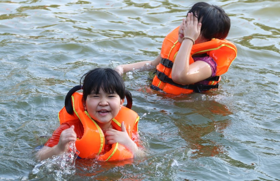 Trẻ thích thú với "bể bơi tự chế" từ ao làng ngoại thành Hà Nội - 6
Nhiều gia đình đưa con nhỏ ra ao tắm vào các buổi chiều. Các em được mặc áo phao bảo hộ, mực nước trong ao cũng không quá sâu và được phân thành từng lớp cho phù hợp lứa tuổi.
