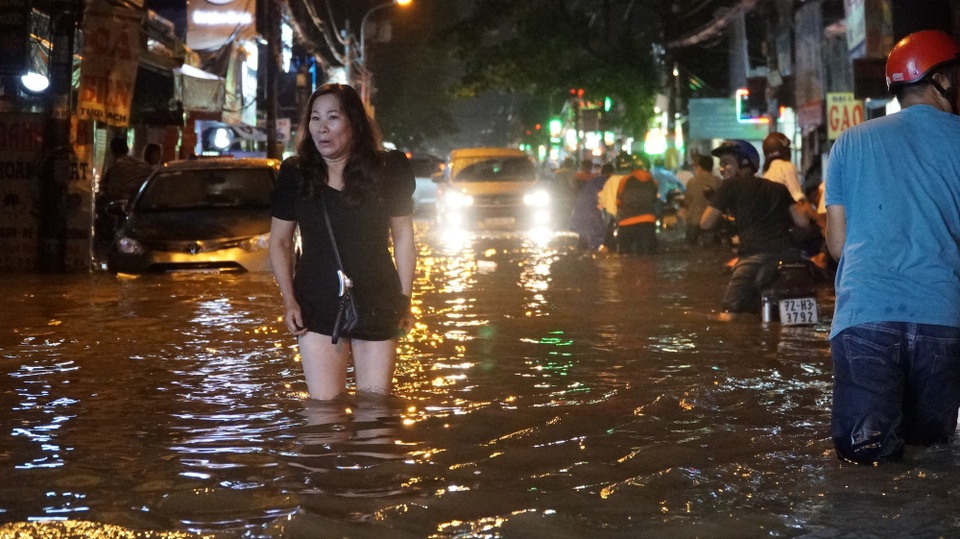 TPHCM: Mưa lớn kéo dài, nhiều tuyến đường ngập qua yên xe máy - 7 Một phụ nữ ngán ngẫm đi bộ qua đường này