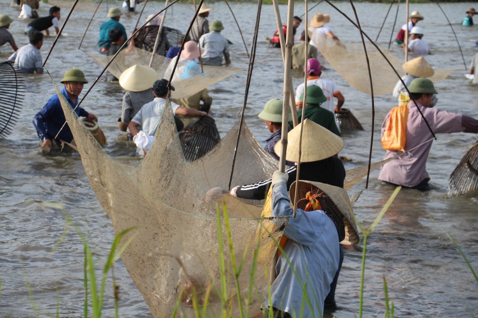 Hàng trăm người dân lao xuống đầm tìm vận may - 11 Người dân quan niệm, trong ngày này, ai bắt được cá to và nhiều thì sẽ gặp may mắn trong năm